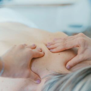 Massage therapist massaging older woman’s back representing dealing with difficult customers and massage therapy complaints