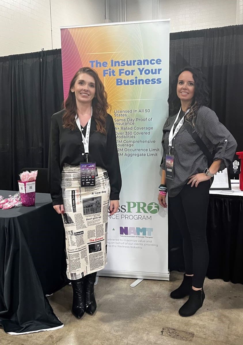 A team photo of WellnessPro Insurance employees standing together at a beauty convention, explaining professional liability insurance claims examples and mitigating business risks with coverage.