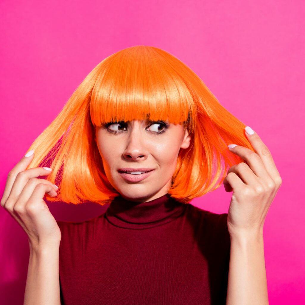 Woman looks bewildered at her short, botched red hair as if considering hair salon lawsuits. A hair color consultation form can prevent bad hair dye and color job claims and these pictures of bad hair dye jobs.