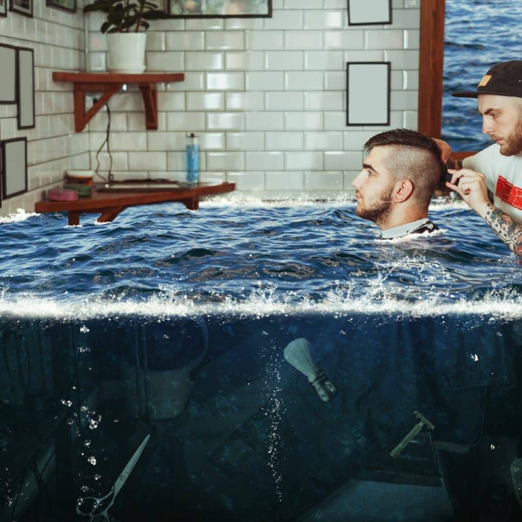 Man seated in a barbershop chair is getting his hair cut by a barber. Meanwhile, they’re surrounded by water from a flooded salon. A barbershop with this much standing water would face serious mold growth signs of water damage in the walls.