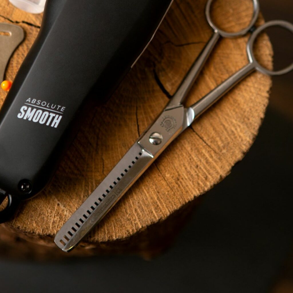 A barber’s beard trimmer and electric razor posed next to a pair of hair thinning shears.