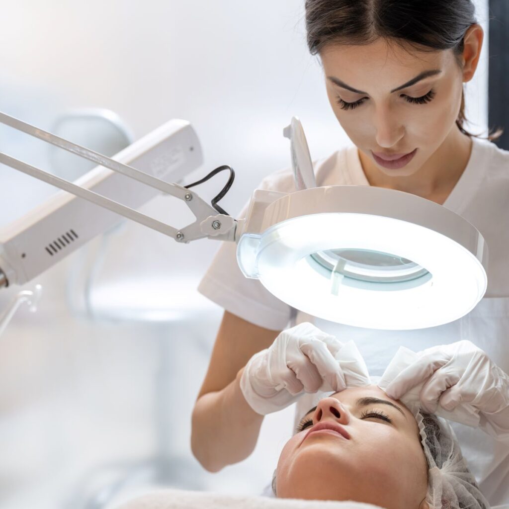 Basic esthetician or master esthetician wears gloves while performing extractions on a client, demonstrating master esthetician requirements for cleanliness.