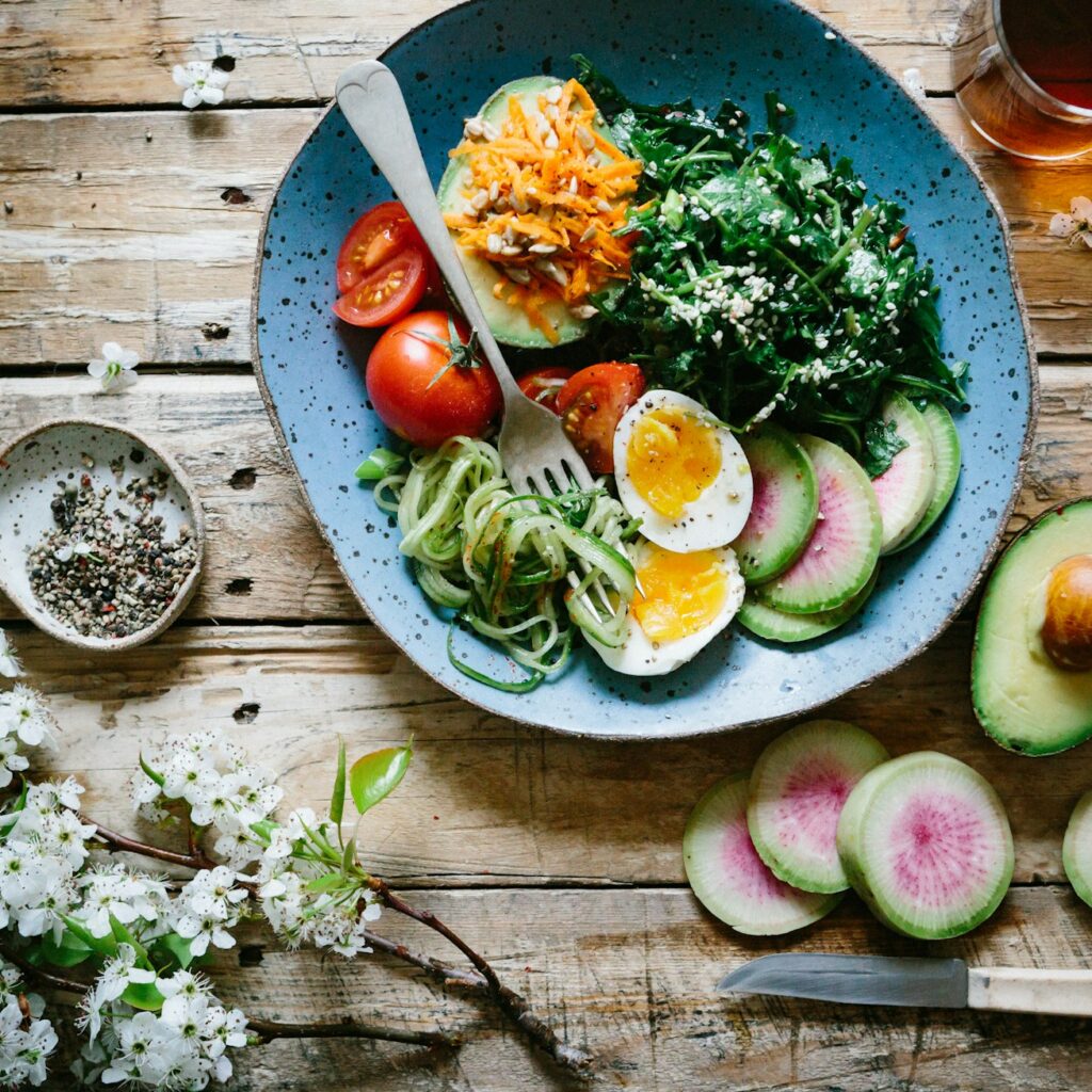 A plate of vegetables, eggs, tomatoes, and seasoning, demonstrating the eating habits of someone who has received good nutritional guidance and advice from a nutritionist.