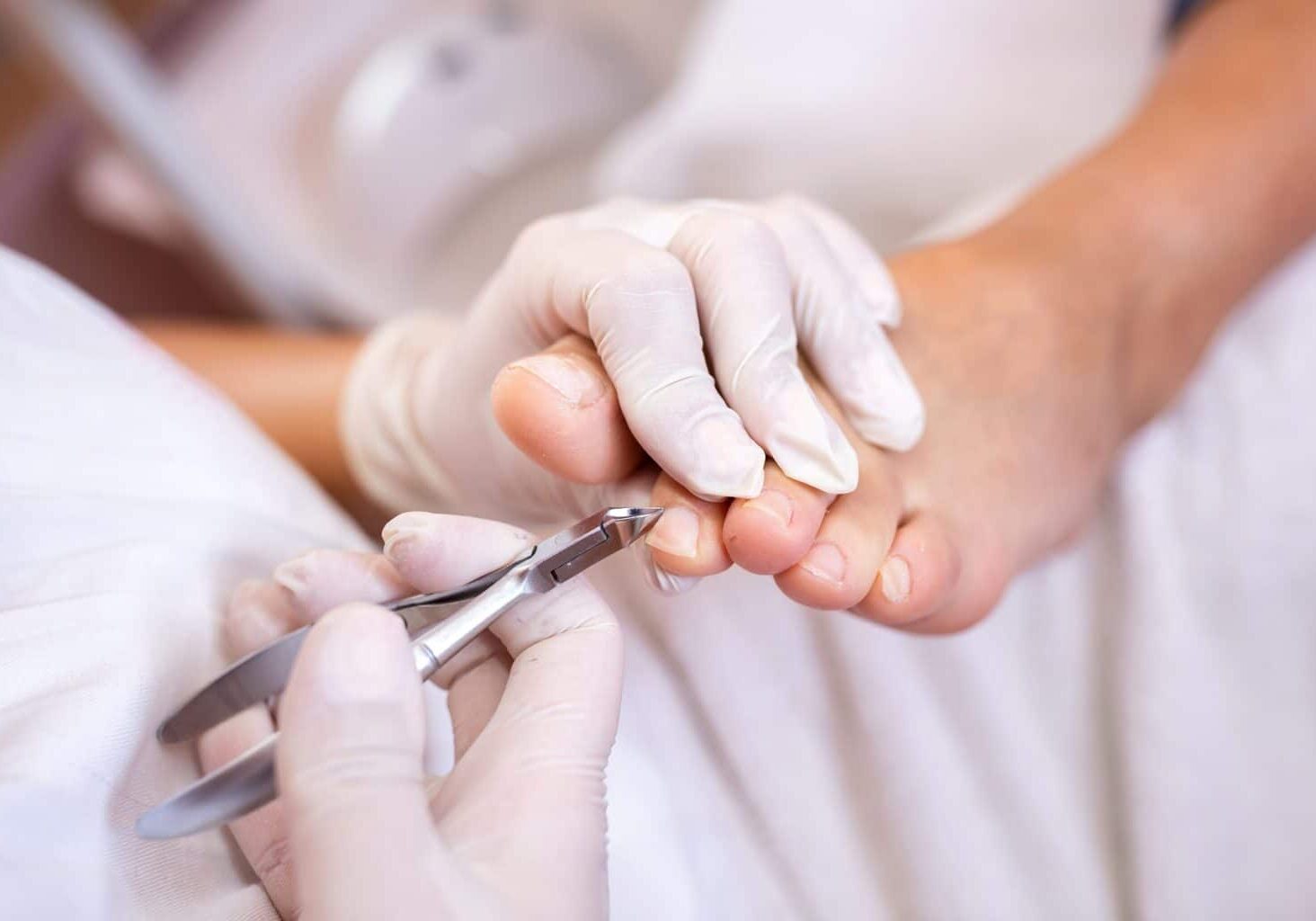 Picture of a nail technician doing a cut during a pedicure.