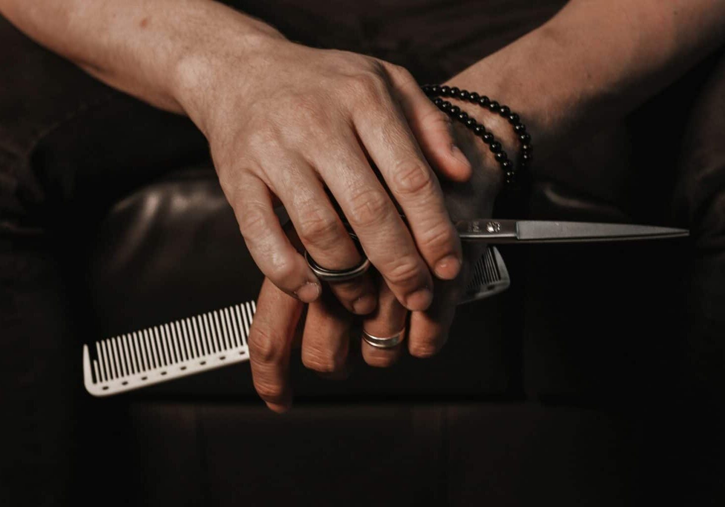 A hair stylist holding scissors with a repetitive strain injury from hairdressing