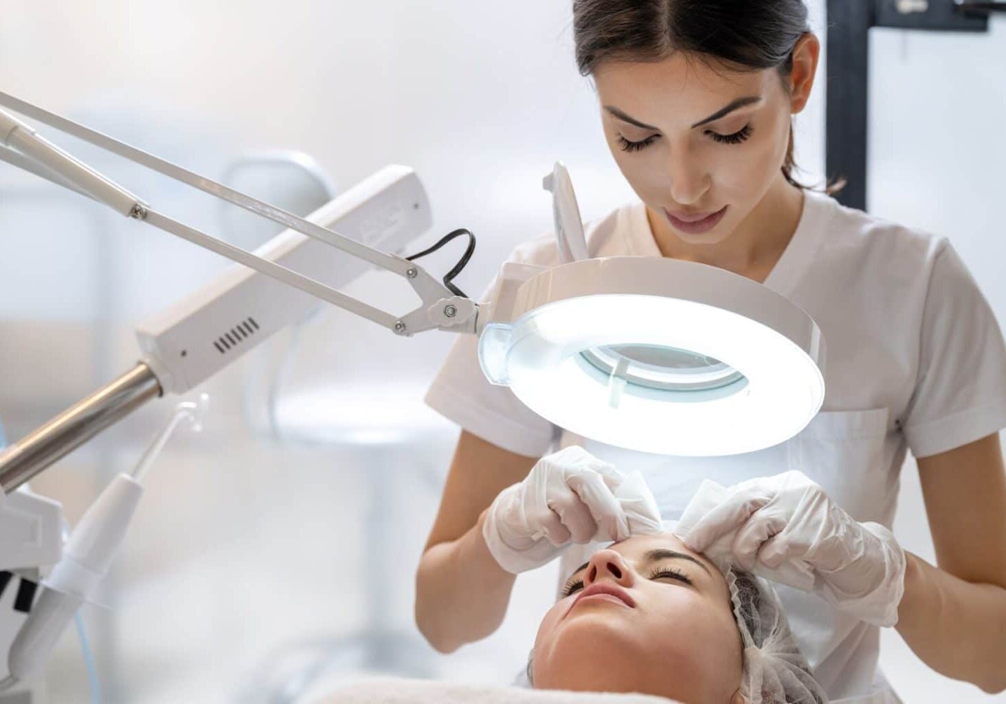 Basic esthetician or master esthetician wears gloves while performing extractions on a client, demonstrating master esthetician requirements for cleanliness.