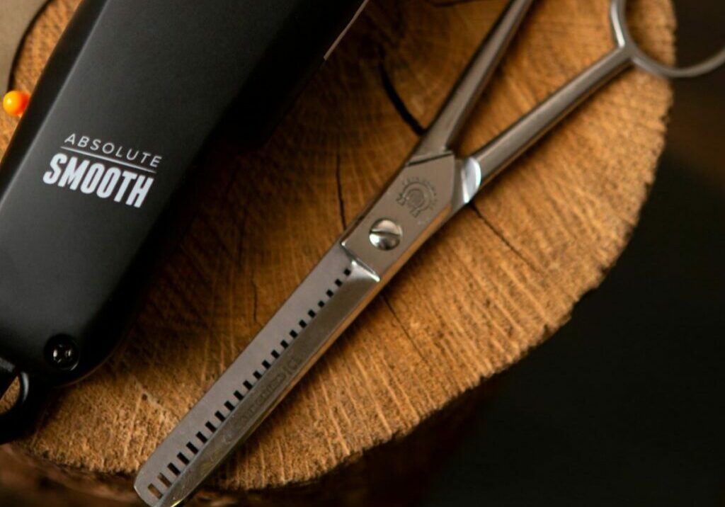 A barber’s beard trimmer and electric razor posed next to a pair of hair thinning shears.