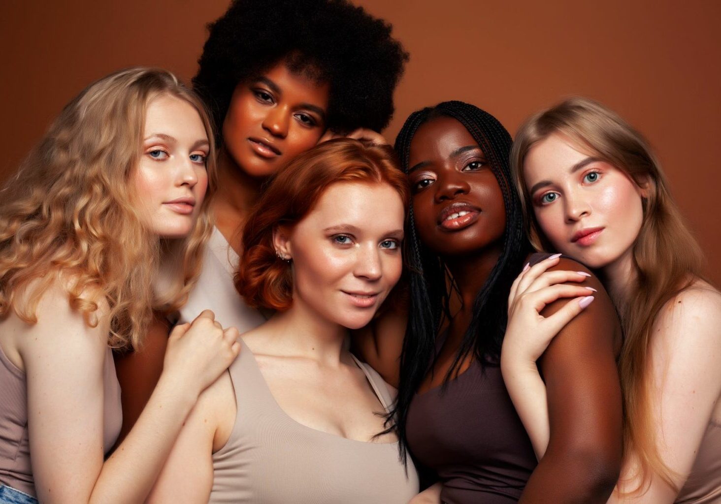 Five women pose together in one photo, representing different types of hair and ethnicity. Learning how to style different hair types is crucial for inclusion and serving happy clients.