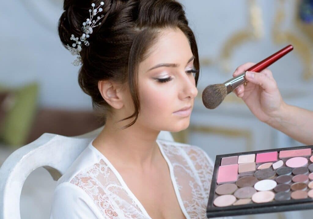 Bride getting makeup done by a makeup artist who is considering makeup artist policies like refunds and cancellation