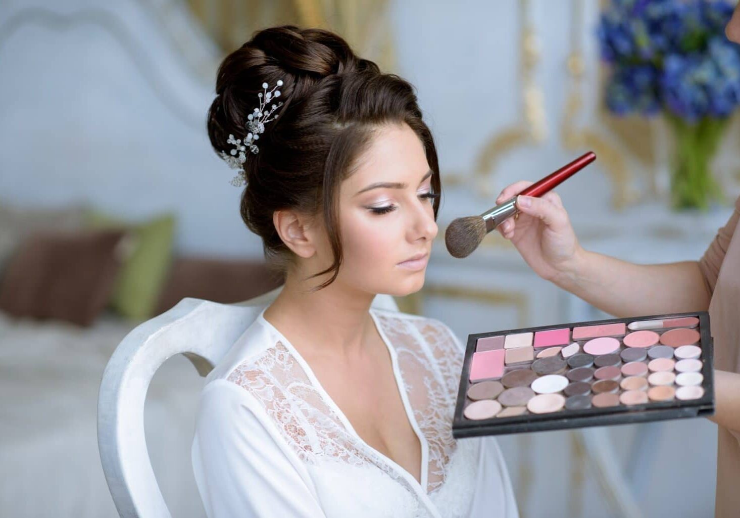 Bride getting makeup done by a makeup artist who is considering makeup artist policies like refunds and cancellation