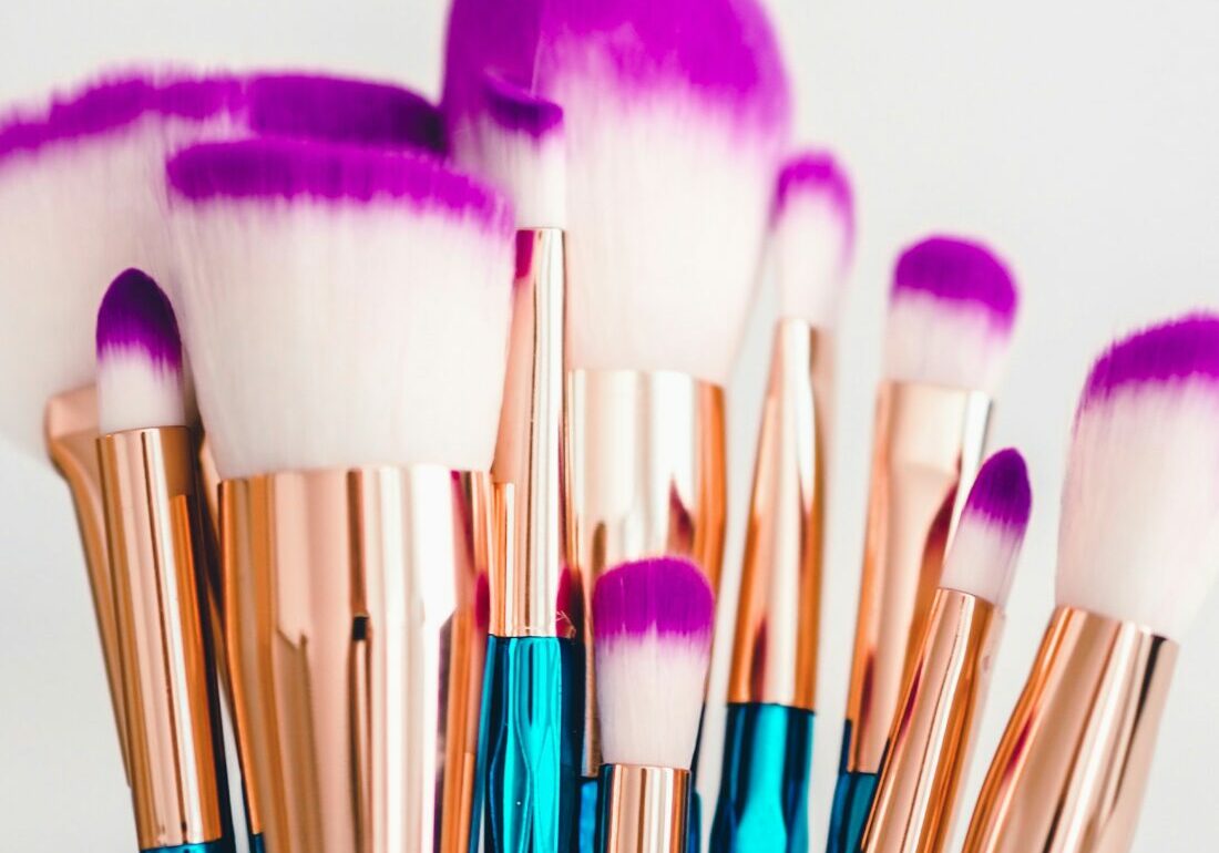 Blue, gold, and purple makeup brushes, like those that must be cleaned routinely to prevent eye and skin infections from makeup and applicators.